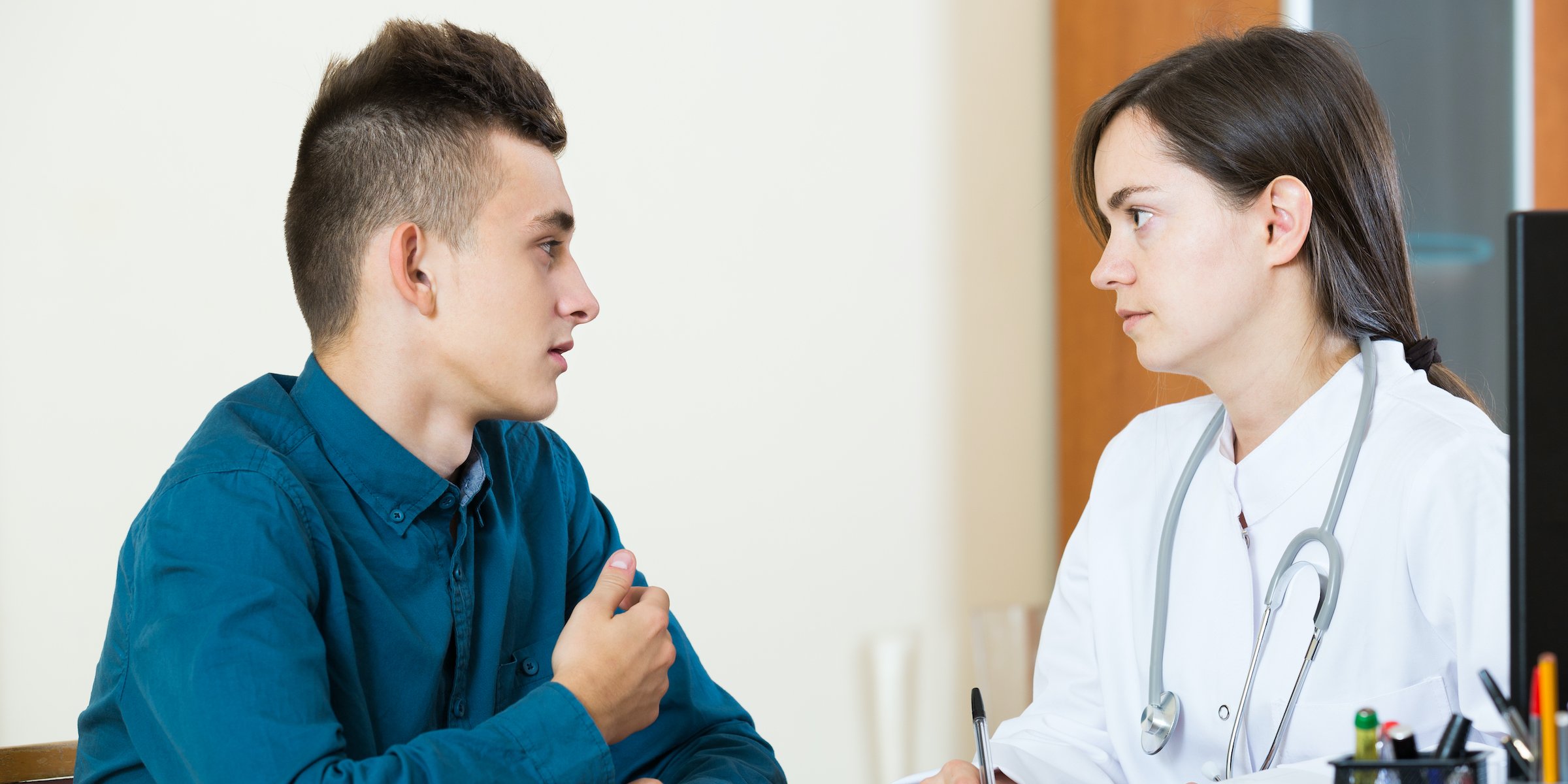 doctor questioning teen patient at office